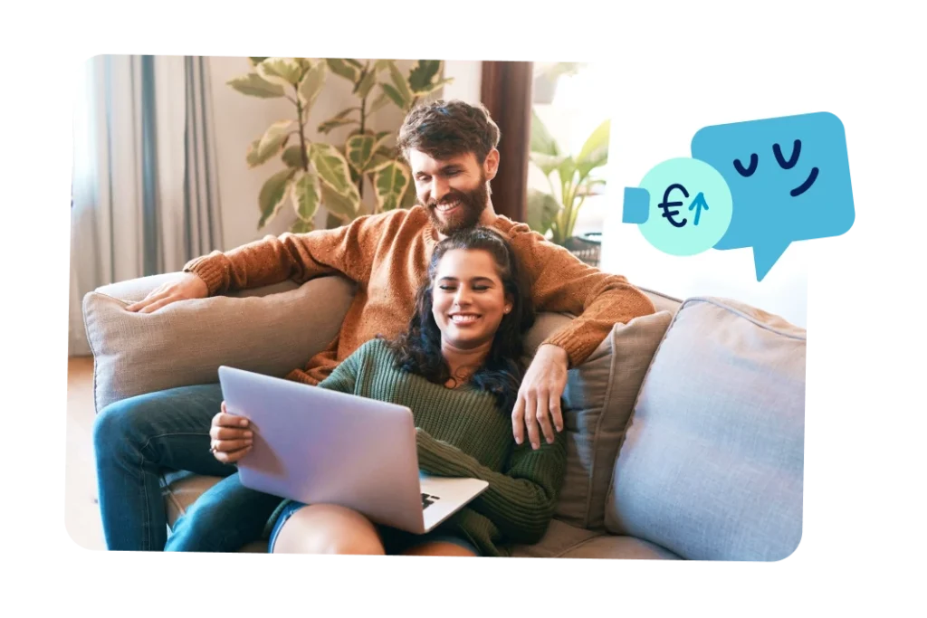 Pareja sentada en el sofá consultando información en un ordenador portátil.